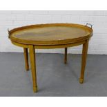 A mahogany tray top table of oval form, with twin brass handles, on tapering supports and spade