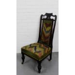 A mahogany framed nursing chair with a tapestry upholstered back and seat on turned supports