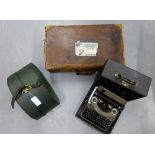 A vintage brown leather suitcase, green leather hat box an a cased typewriter, (3)