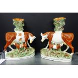 A pair of Staffordshire cow and calf flat back spill vases on oval black lined bases, 27cm high (2)