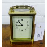 A small French brass cased carriage clock, the white enamel dial with Arabic numerals, stands at