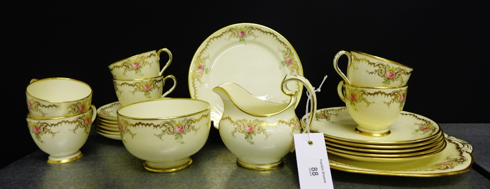 A Grosvenor china honey glazed tea set with rose sprays and gilded rims comprising six cups, six