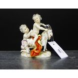 A 19th century porcelain figure group depicting two cherubs and a ram on a rocky mound, with blue