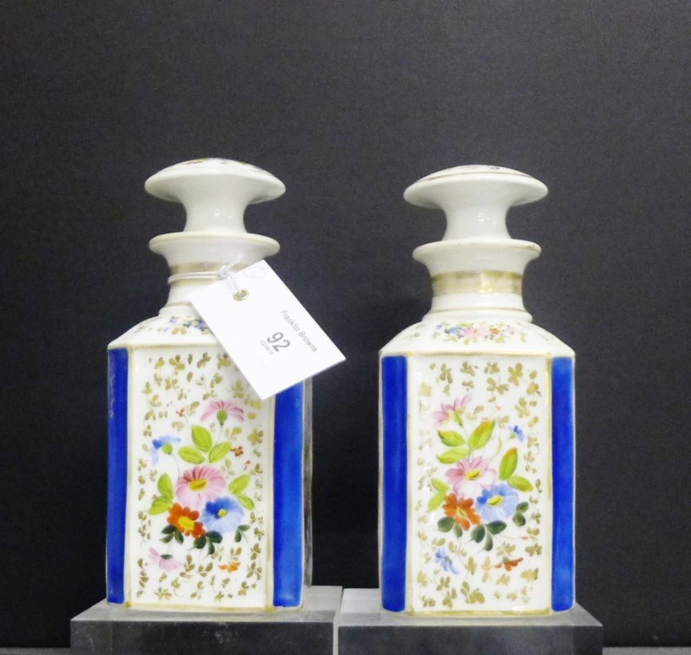 A pair of continental porcelain jar and covers, each of square form, painted with floral sprays