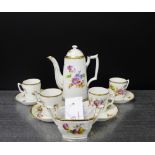 A continental porcelain white glazed coffee set painted with floral sprays within gilded borders,