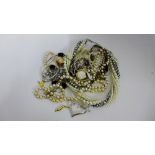 A mixed lot of costume jewellery to include faux pearls, gilt metal chains, brooches, bangles,