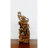 A carved wood figure group of a Lohan with a boy and a deer at his feet on a naturalistic base, 75cm