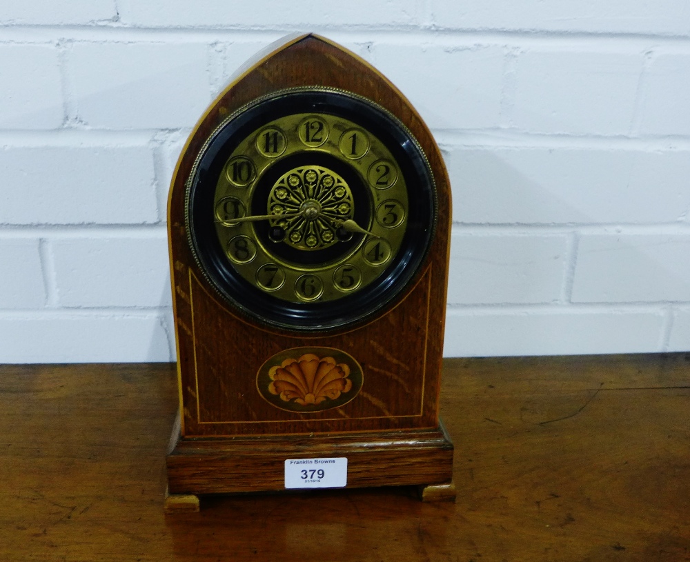 An oak domed top mantle clock with an inlaid paterea to front, with a gilt brass chapter ring with