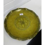 A German Arts & Crafts brass dish, the hand beaten finish with a floral decoration to the centre