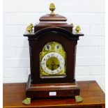 A mahogany cased bracket clock, the arched top with brass acorn finials over a brass dial with