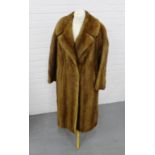 A ladies full length fur coat with an embroidered silk lining