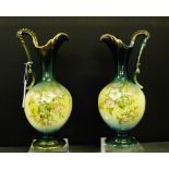 A mirrored pair of late 19th century jugs, painted with floral sprays, 30cm high, (2)