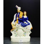 A Staffordshire flat back male and female figure, on an oval gilt lined base, 35cm high