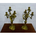 A pair of gilt brass three branch candlesticks in the Rococo style, 53cm high, (2)