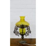 A coppered metal table lamp base with amber glass well and shade