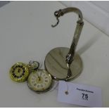 A silver cased fob watch with a silver plated stand together with a smaller gold plated fob watch (