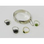 A collection of five gemset silver rings and a silver foliate engraved stiff hinged bracelet (6)