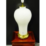 An opaque white glass baluster table lamp base on circular brass effect stand, height excluding