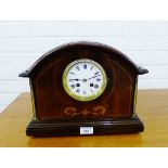 A mahogany and inlaid mantle clock, the domed top over a white enamelled dial with Roman numerals