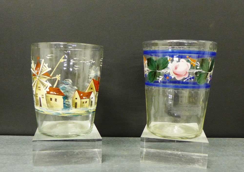 A large floral painted tumbler, together with another painted with a windmill and village scene,