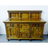 A walnut ledgeback sideboard with rectangular top above two central square cupboards flanked by