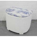 A white painted Lloyd Loom style basket with upholstered top