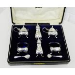 A George V silver condiment set comprising two pepper pots, two open salts and two mustards,