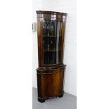 A mahogany corner cabinet, with a glazed door and shelved interior over a cupboard door to the base,