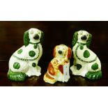 A pair of Staffordshire green and white chimney spaniels together with another smaller in brown