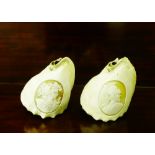 Two carved conch shells depicting Romanesque male and female figures, 11cm long, (2)