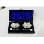 Edwardian silver repousee salts and spoons, in a cased presentation box, with makers marks for
