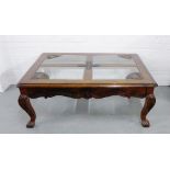 A stained hardwood coffee table with four glass panels on cabriole legs with paw feet, 50 x 128cm