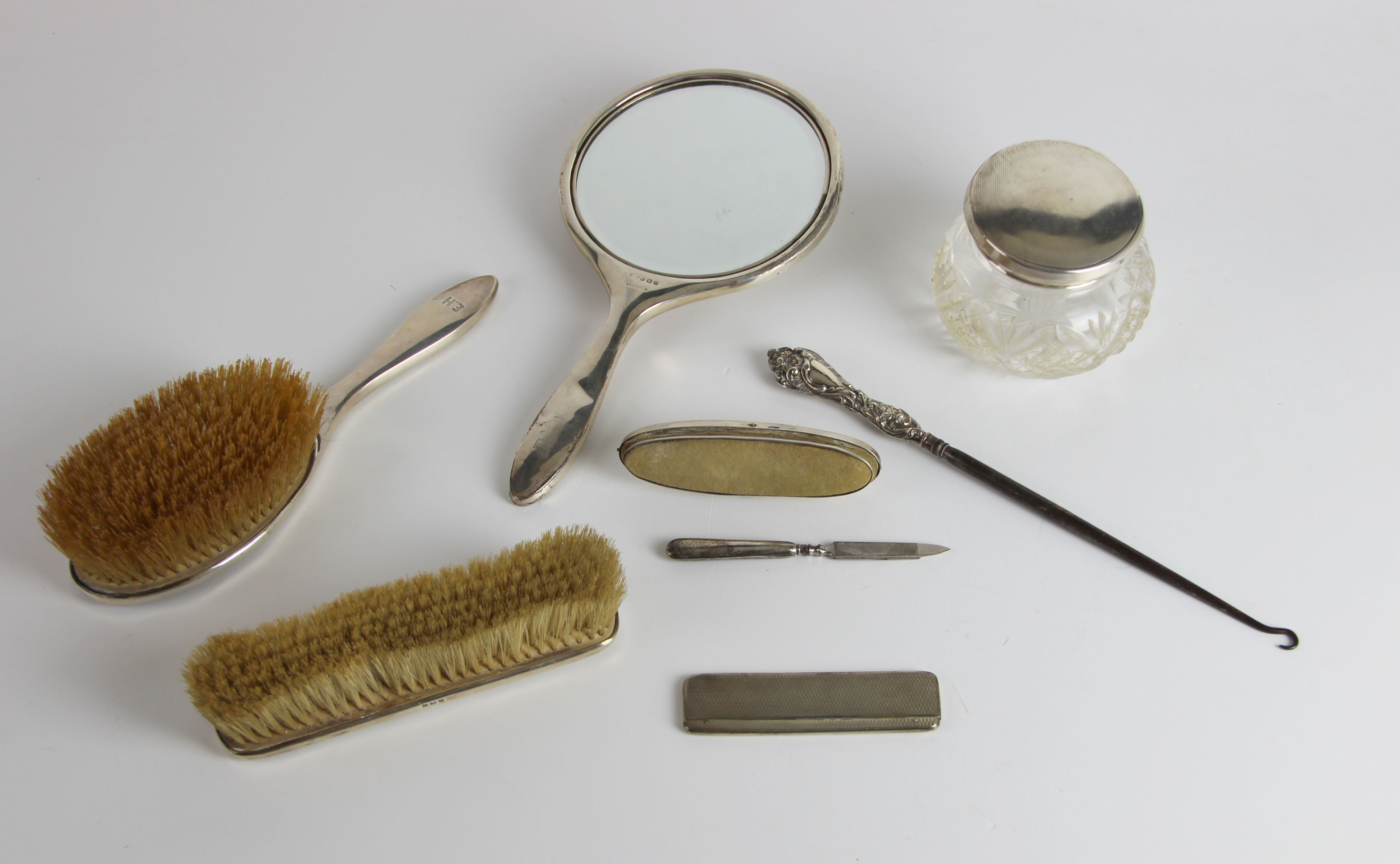 A silver backed dressing table set, engine turned, comprising cut glass powder bowl with silver