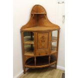 A free standing satinwood corner unit, central small cupboard over drawer with two shelves either