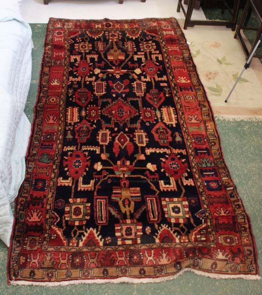 A claret ground carpet of traditional asymmetric design, probably Turkish, c1950, 288 x 140cm