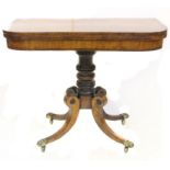 A William IV card table with cross banded top on sabre legs with brass lion paw terminals and