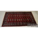 A modern Hamedan wool rug on cotton weft, claret ground with a design of medallions in black, pink