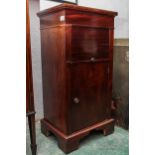 A mid-20th century mahogany pot cupboard, with roll front compartment above a single cupboard