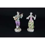 A pair of Continental figures of musicians, she playing castanets, he a lute on foliate scroll