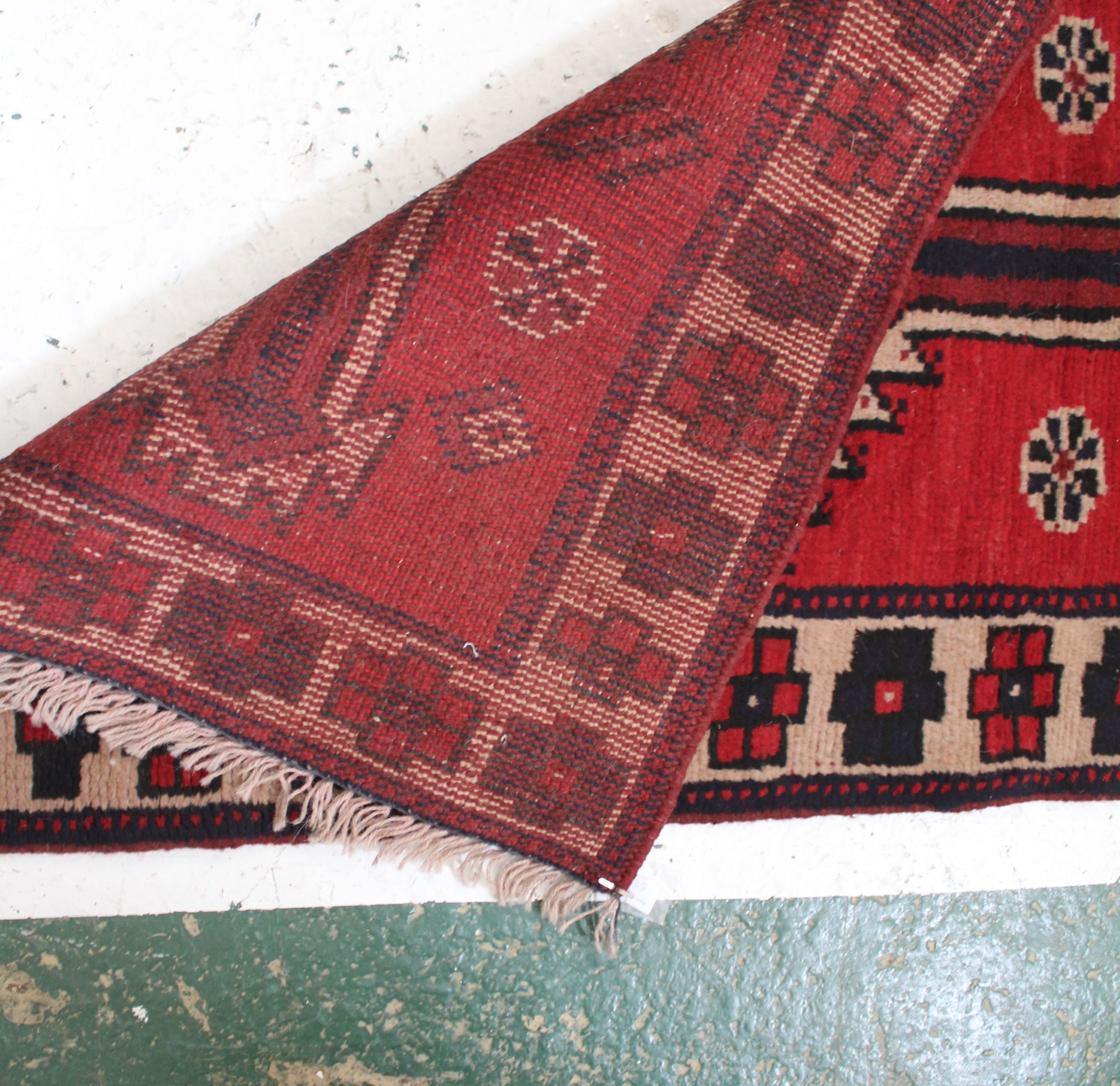 An Afghani wool runner, of thick pile, central banding of joined medallions on claret ground, the - Image 4 of 4
