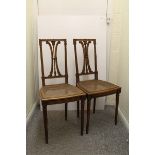 A pair of French carved walnut bedroom chairs, with bound 'c' scroll back splats, carved seats on