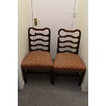 A pair of oak framed ladder back chairs with salmon coloured upholstered seats with plain legs and
