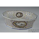 A Nymphenberg porcelain pierced basket, with en grissaile panels of views, the base naming the view,