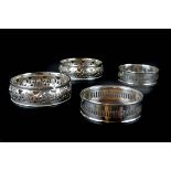 Two pairs of silver plated coasters, one pair of Regency style pierced with foliate scrolls; the