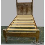 A French lined oak Arts and Crafts carved single bed frame, of long size, the headboard carved