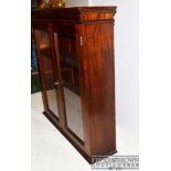 A mahogany glazed bookcase, two doors opening to reveal two adjustable shelves with key, 110 x 107.5