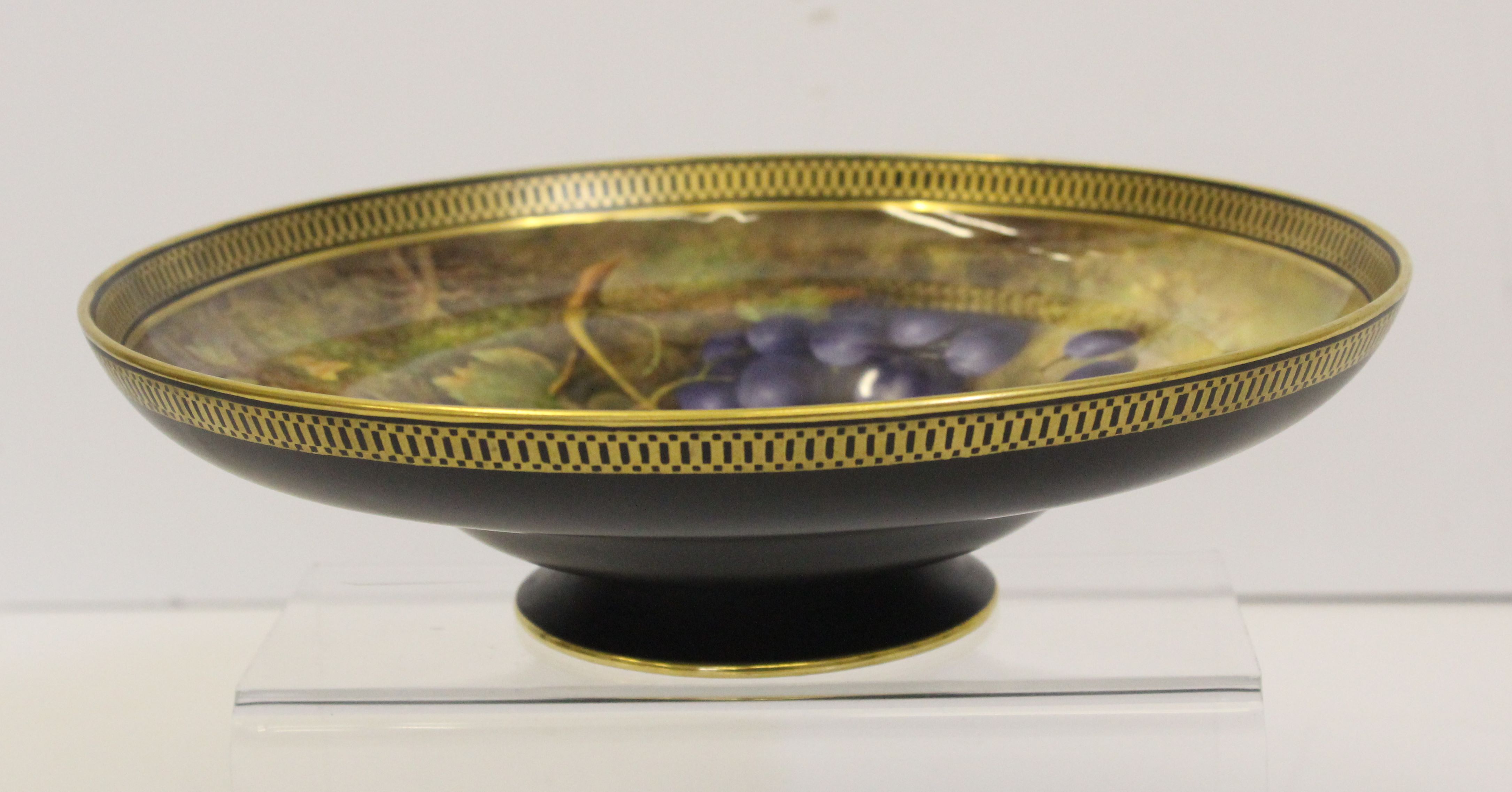 A Royal Worcester porcelain pedestal bowl, signed R.Sebright, painted with apples and grapes against