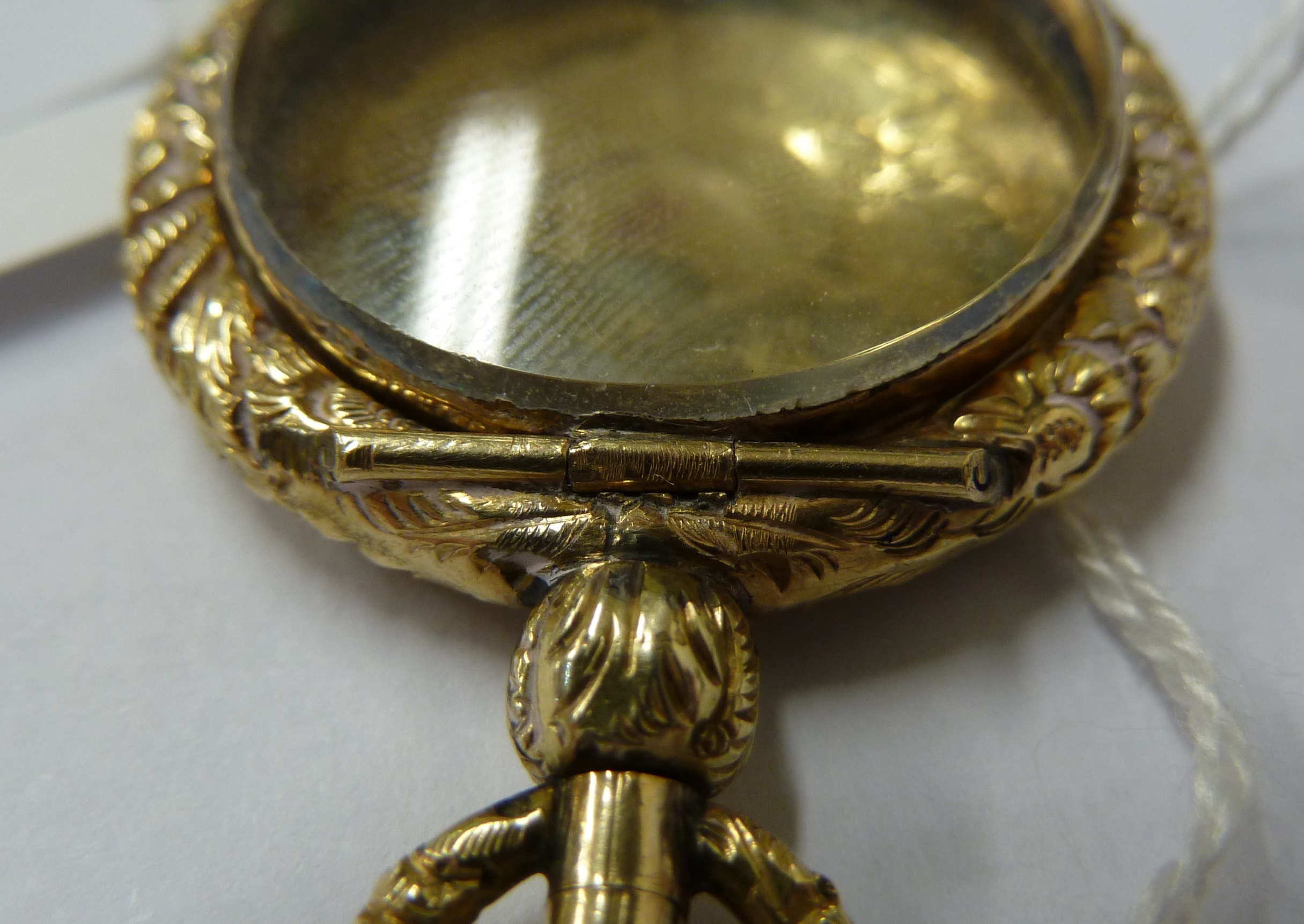 A small 15ct yellow gold locket, c1840, of circular form with carved floral borders - Image 7 of 7