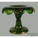 A Bohemian dark green glass tazza, circular with scalloped everted rim, the whole gilded with