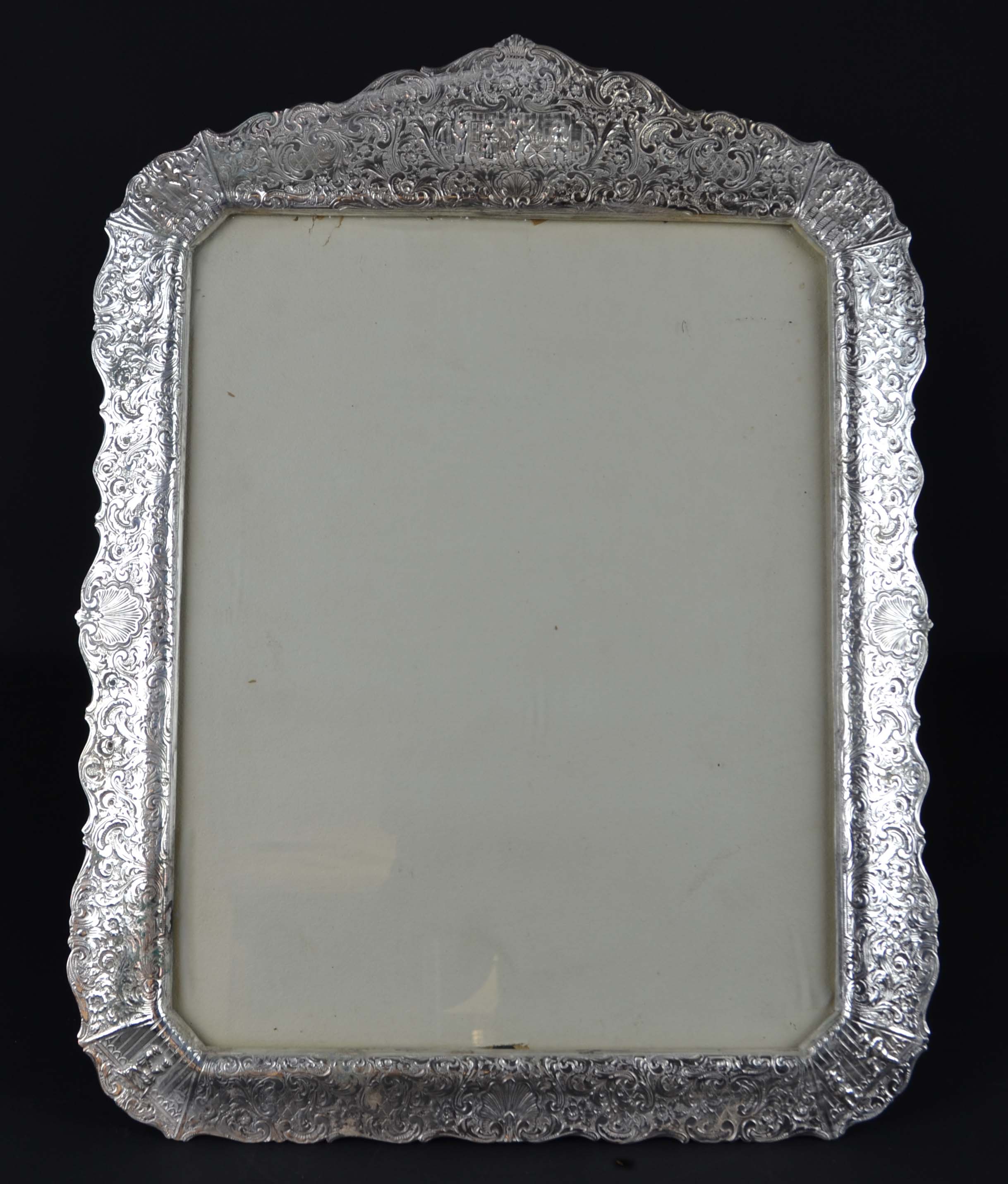 A large Dutch style silver plated rectangular photograph frame, of shaped edge, the copper body